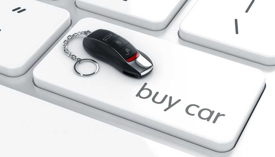 Representación 3D de un llavero con forma de auto de lujo sobre el teclado de una computadora