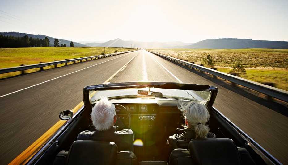 Pareja conduce un auto convertible