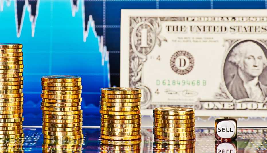 Billete de dólar, monedas apiladas, y un cubo que dice vender, sobre una gráfica estadística.