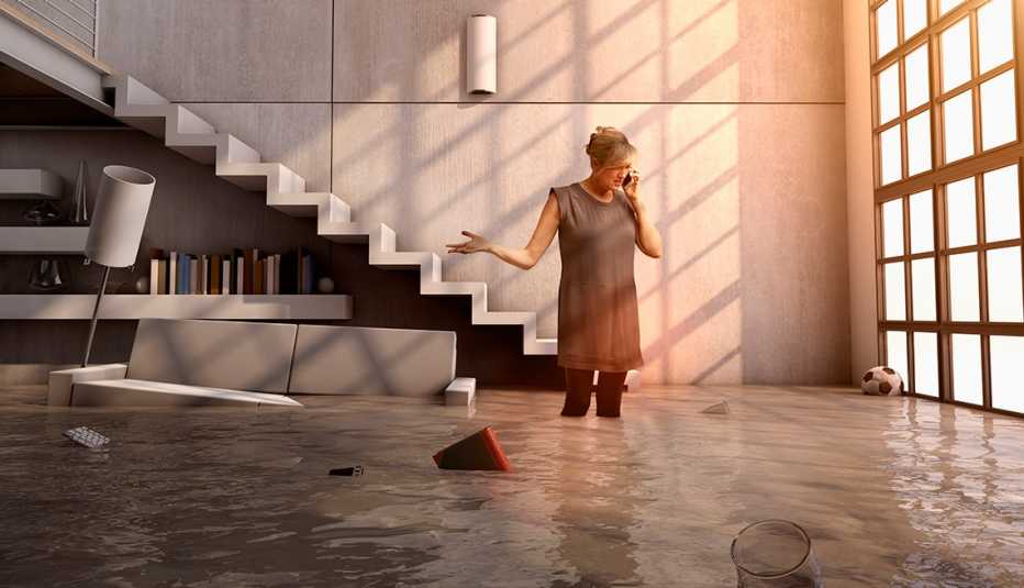 Mujer llamando por teléfono en medio de un apartamento inundado