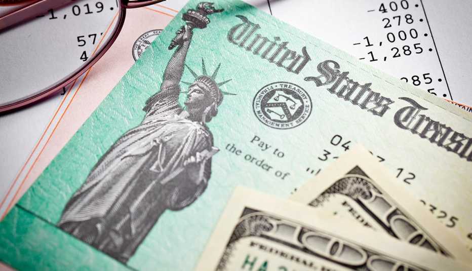 Bonos del tesoro, lentes y un billete de 100 dólares