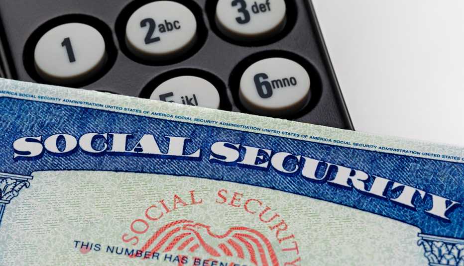 Una tarjeta deseguro social frente a un teclado con números.
