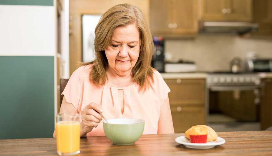 Mujer mayor come sus alimentos