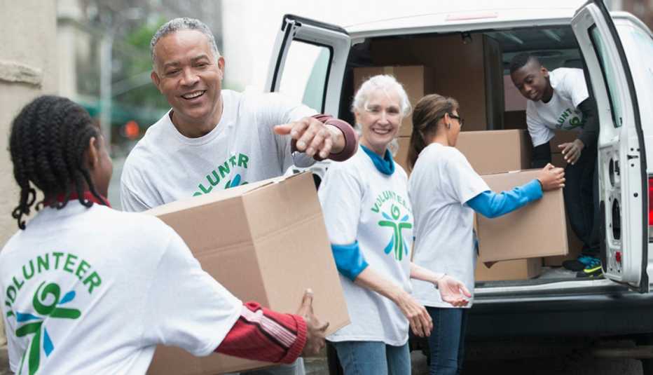 Grupo de voluntarios carga cajas en un vehículo