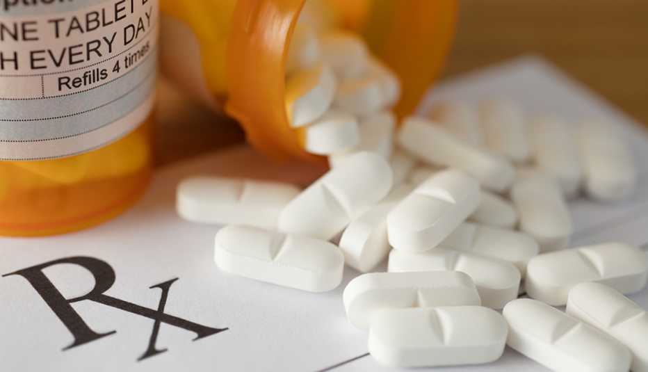 Un frasco con pastillas sobre una prescripción médica