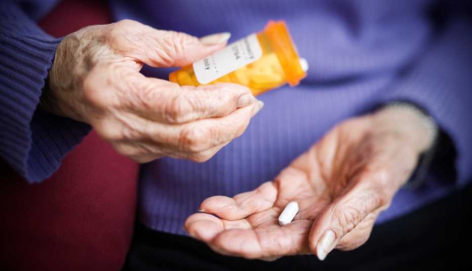 Una mujer pone una pastilla en su mano
