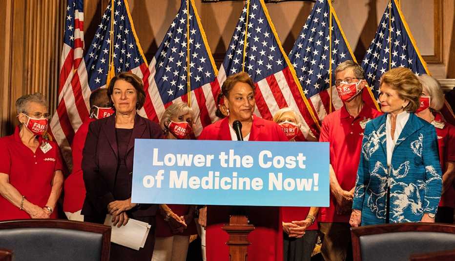 La directora ejecutiva de AARP, Jo Ann Jenkins, se dirige a una audiencia rodeada de varias personas entre ellas la senadora Amy Klobuchar de Minnesota y Debbie Stabenow de Michigan