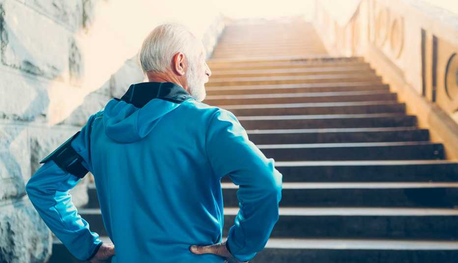 hombre mayor con sudadera subiendo unas escaleras