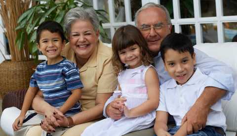 Portrato de abuelos Hispanos abrazando a sus nietos.
