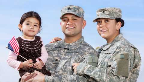Pareja vestida con uniforme militar posa junto a su hija para una foto