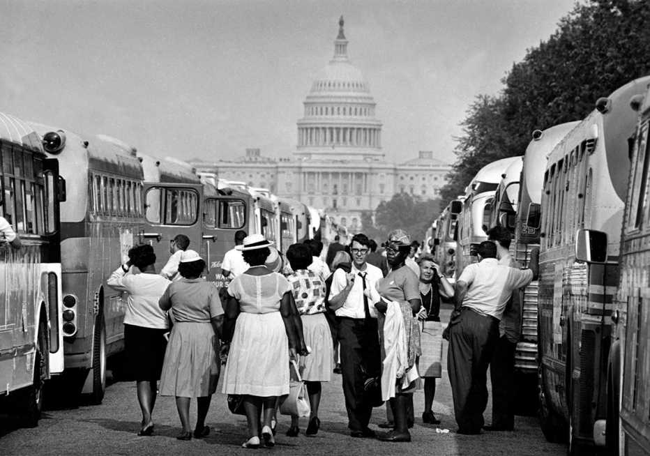 pasajeros de los autobuses chárter caminan caminan entre vehículos hacia el capitolio de ee.uu. durante la marcha sobre washington