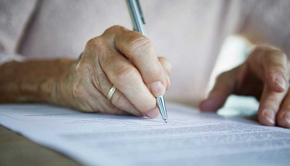 Una mujer firma un documento