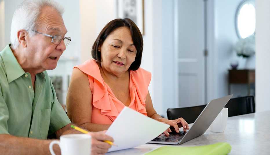 Una pareja revisando sus finanzas haciendo un presupuesto para los gastos de atención a largo plazo.