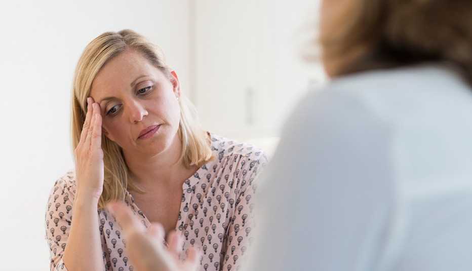 Dos mujeres hablando, ambas tristes.