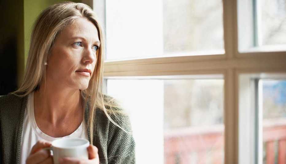 Mujer mirando a través de una ventana.