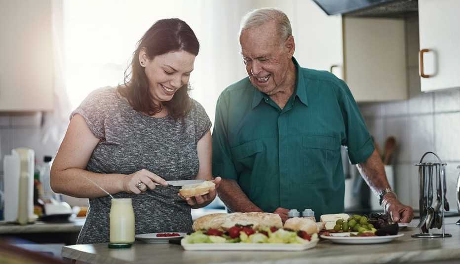 Una mujer haciendo un sándwich a su padre.