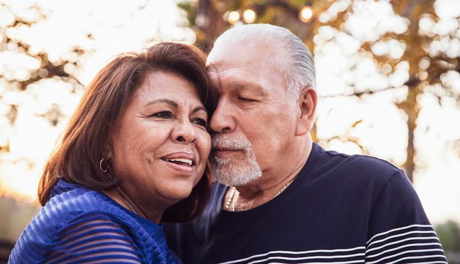Una pareja abrazándose al aire libre.