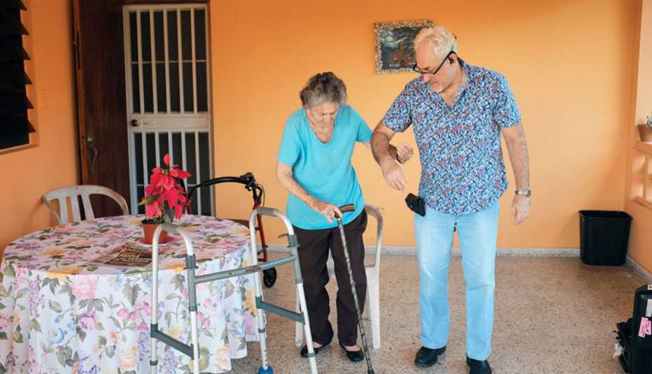Edgardo Vélez ayuda a su madre, Encarnita Munich, a caminar 