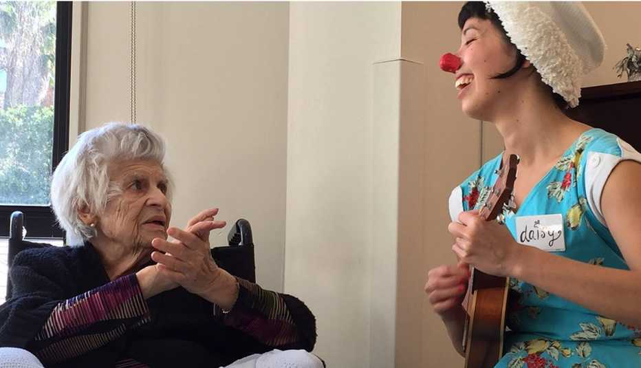 Comendiante con nariz de payaso divirtiendo a paciente de Alzheimer