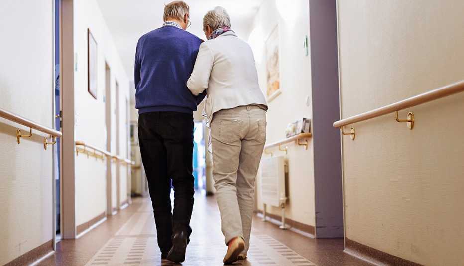 Una pareja mayor camina por un pasillo