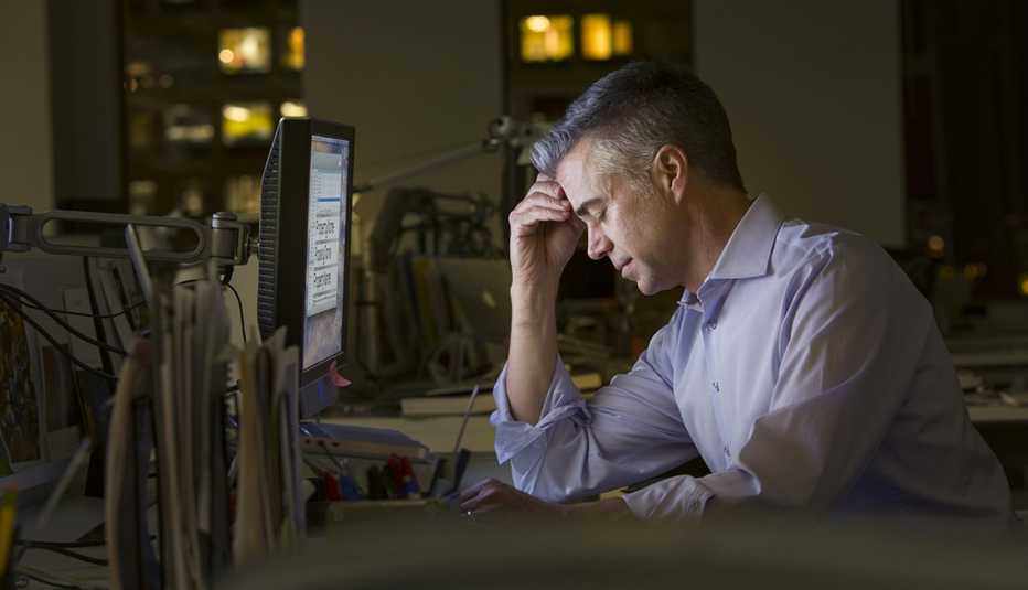 Hombre con estrés frente a una computadora 