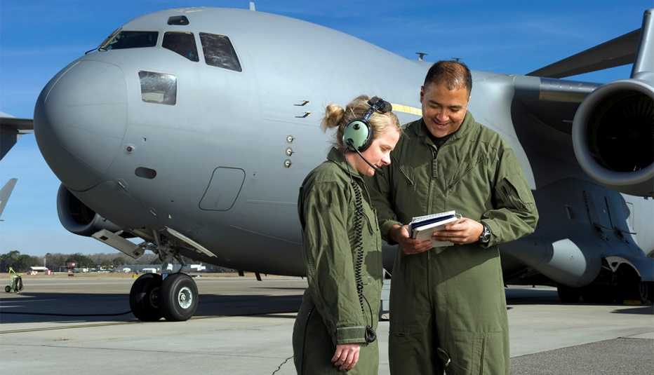 Soldados de la Fuerza Aérea de EE. UU. parados frente a un avión militar