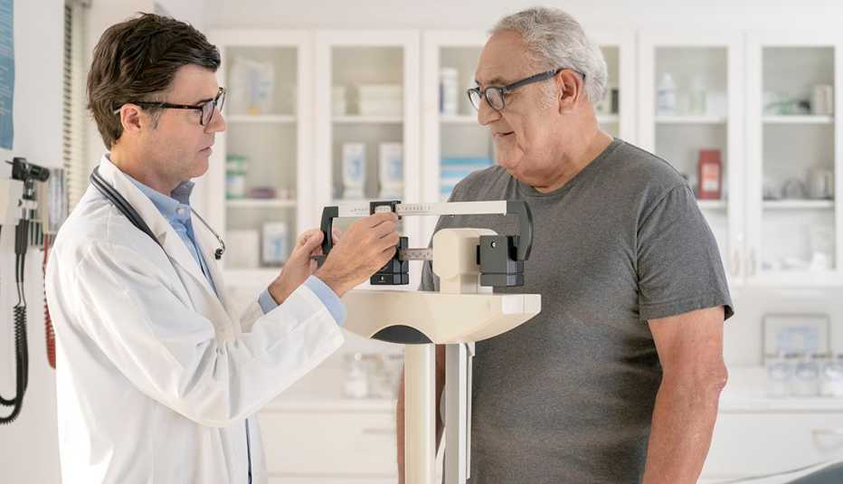 Médico pesando a su paciente