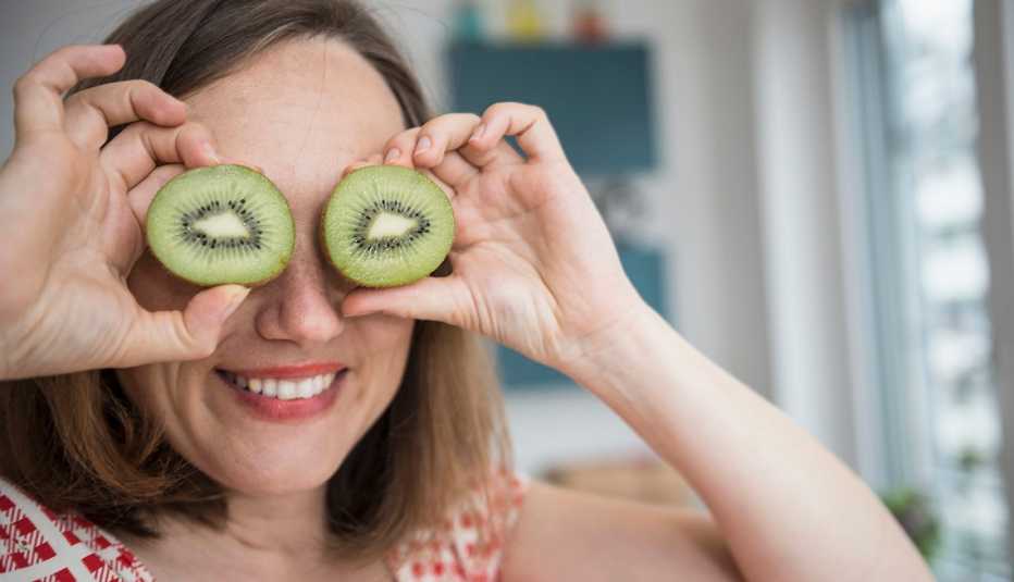 Una mujer se lleva unas rebanadas de kiwi a los ojos