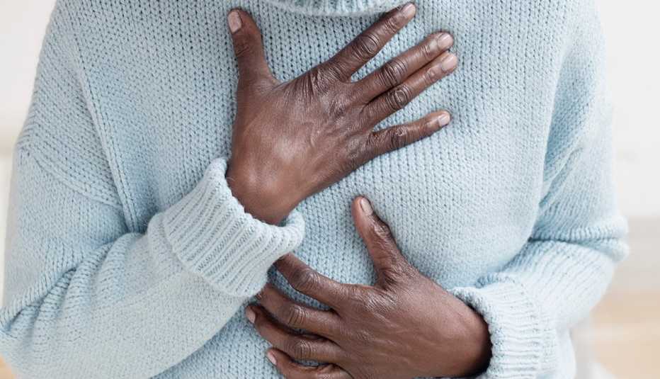 Una mujer se lleva la mano al pecho en señal de dolor.