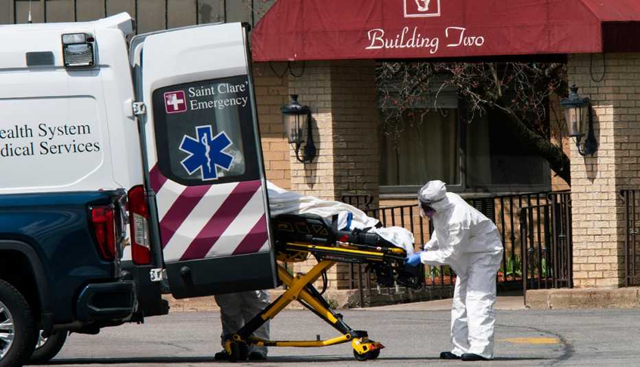 Empleados médicos suben una persona fallecida a una ambulancia