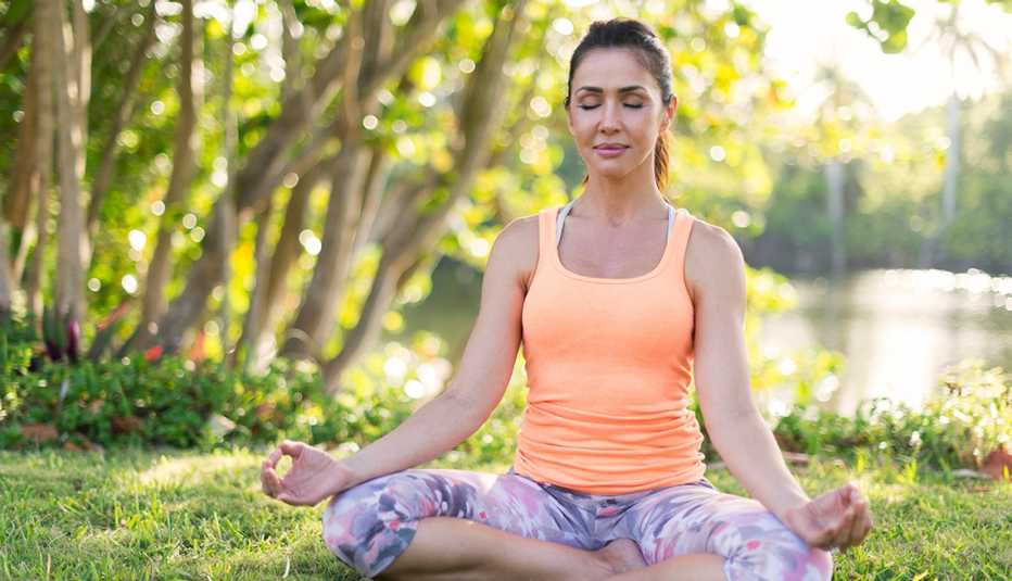 Una mujer meditando en un parque
