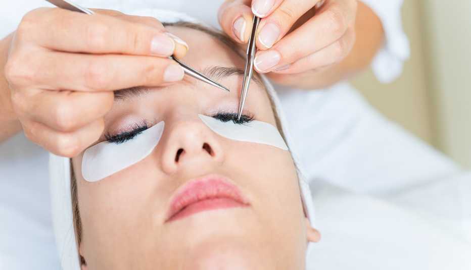 Una esteticista le pone pestañas postizas a una mujer