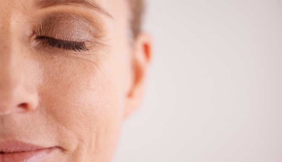 Perfil de una mujer con los ojos cerrados y maquillados
