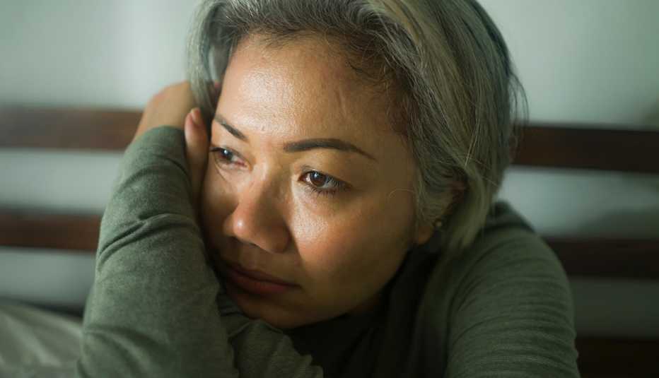 Mujer deprimida, apoya su cabeza en su brazo