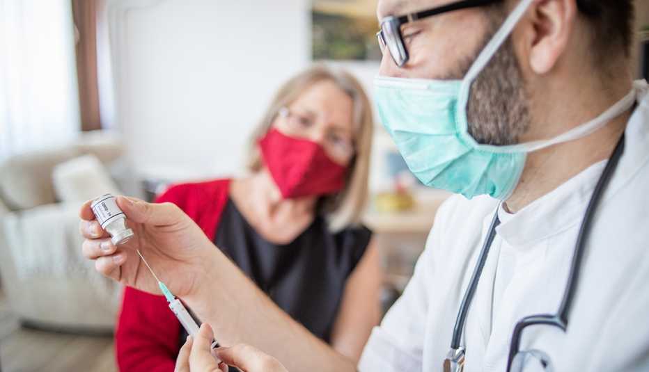 Una mujer en la oficina de su médico esperando recibir su vacuna de refuerzo contra la COVID