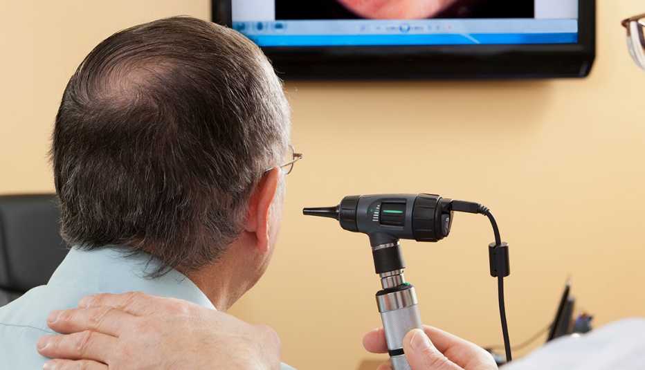 Un doctor revisa la audición de un paciente
