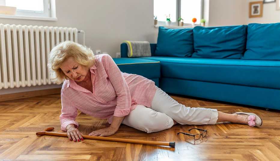 Una mujer tirada en el piso de su sala luego de haberse caído