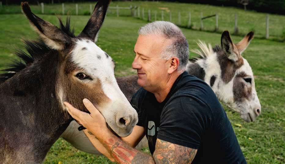 Heath Haug acaricia uno de sus burros miniatura en su granja