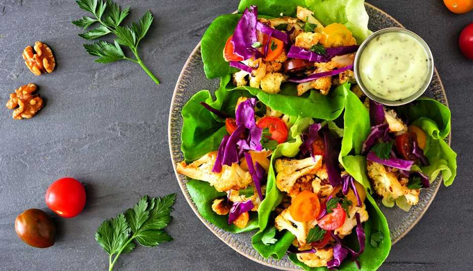 Vegetales en hojas de lechuga y salsa para remojar