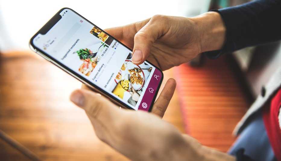Una mujer revisa una orden de comida en su teléfono móvil