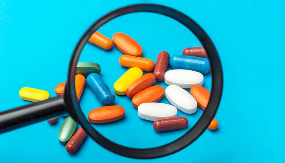 Lupa sobre varias pastillas de suplementos de colores