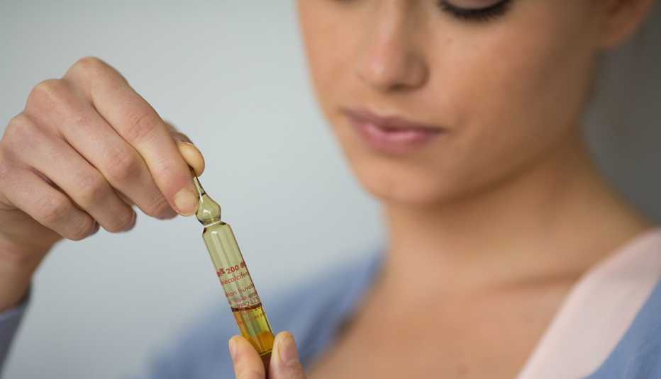 Mujer examinando una vitamina