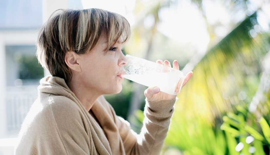Mujer tomándose un vaso de jugo