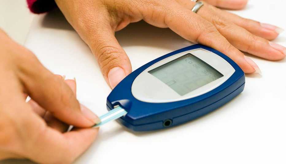 Mujer haciendo una prueba de nivel de azúcar -  Síntomas de la falta de carbohidratos en la dieta