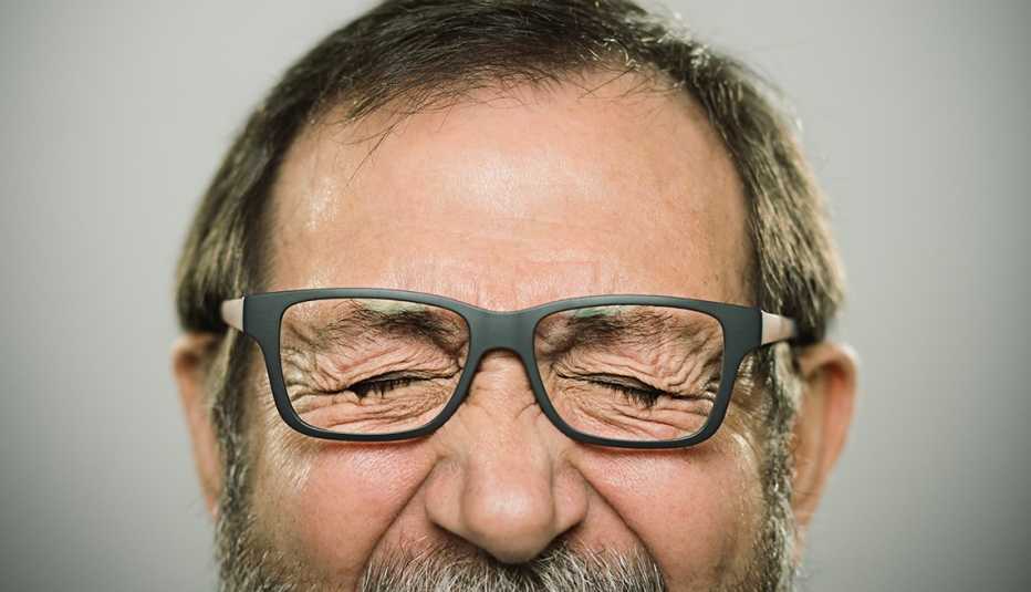 Hombre con sus ojos cerrados apretados