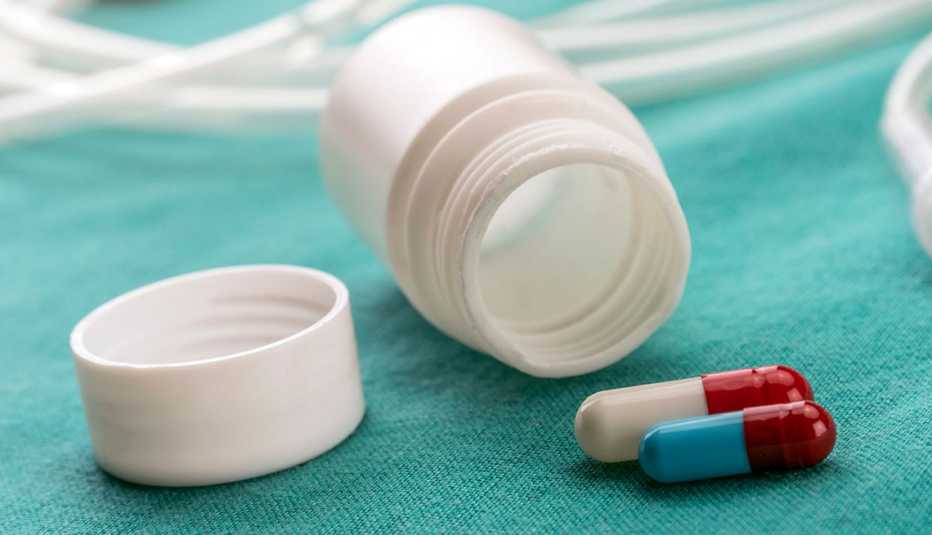 Frasco de pastillas vacío y dos pastillas