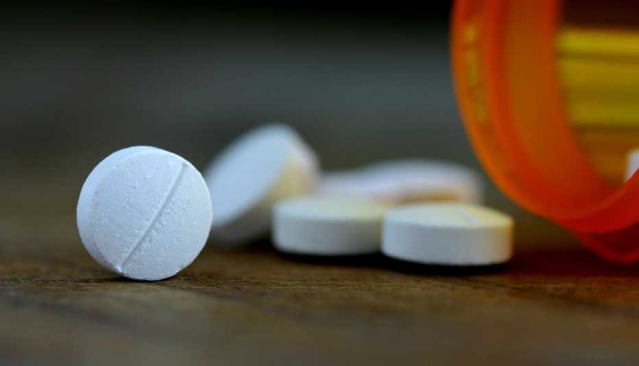 Pastillas en frente de un frasco de medicinas
