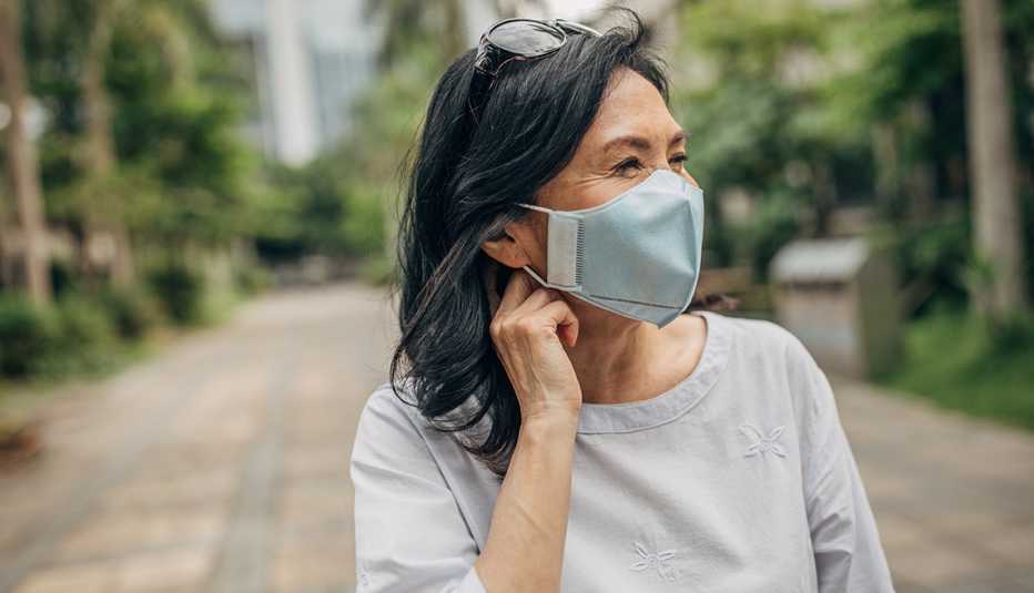 Una mujer usa mascarilla al aire libre
