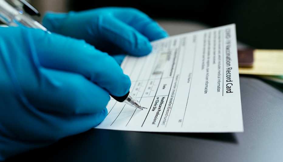 Médico llenando una tarjeta de vacunas