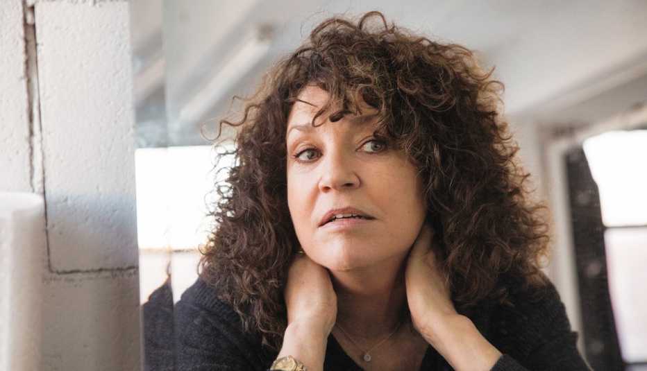 Una mujer con su cabello rizo se mira en el espejo